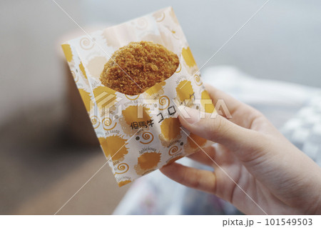 揚げたての但馬牛コロッケを持つ手 101549503