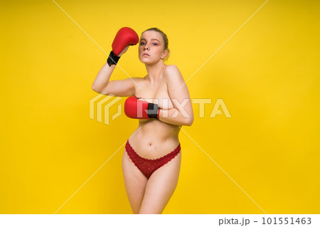 Seductive young and fit female fighter posing in gloves in studio Seductive young and fit female fighter posing in gloves in studio 101551463