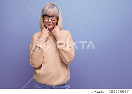 middle-aged woman in gray hair in a stylish jacket on a studio background with copy space 101553627