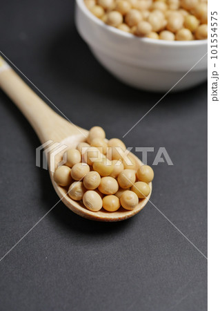 close up of Raw soy bean seed on spoon over black background close up of Raw soy bean seed on spoon over black background 101554575
