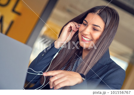 Young Latin Project Manager Putting On Headphones and Working on Laptop Computer in Busy Creative Office Environment. Young Latin Project Manager Putting On Headphones and Working on Laptop Computer in Busy Creative Office Environment. 101556767