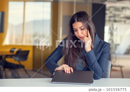Businesswoman yawning while working with a laptop computer in the office, a woman in casual office lifestyle concept. Businesswoman yawning while working with a laptop computer in the office, a woman in casual office lifestyle concept. 101556775