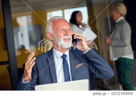 Mature businessman working on laptop. Handsome mature business leader sitting in a modern office Mature businessman working on laptop. Handsome mature business leader sitting in a modern office 101556800