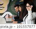 Business team collaborating on project together, using laptops. Business colleagues in casual working together in contemporary office space. 101557077