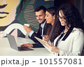 Business team collaborating on project together, using laptops. Business colleagues in casual working together in contemporary office space. 101557081