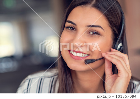 Young friendly operator woman agent with headsets working in a call centre. Young friendly operator woman agent with headsets working in a call centre. 101557094