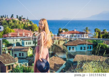 Woman tourist in Old town Kaleici in Antalya. Turkiye. Panoramic view of Antalya Old Town port, Taurus mountains and Mediterrranean Sea, Turkey Woman tourist in Old town Kaleici in Antalya. Turkiye. Panoramic view of Antalya Old Town port, Taurus mountains and Mediterrranean Sea, Turkey 101559292