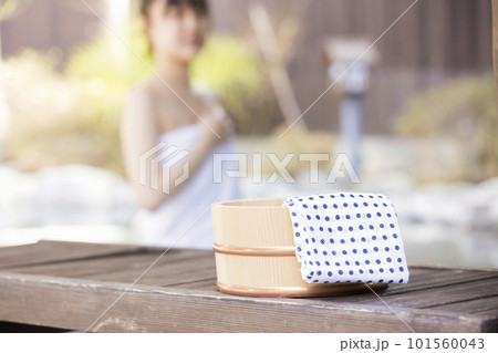 のんびり露天風呂に入る若い女性と風呂桶 101560043