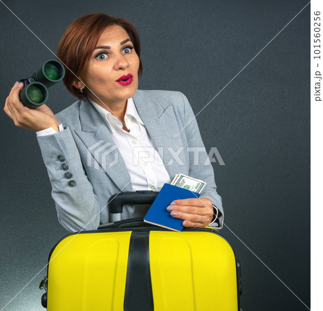 Happy beautiful business woman looks with binoculars in surprise towards her travel. Happy beautiful business woman looks with binoculars in surprise towards her travel. 101560256