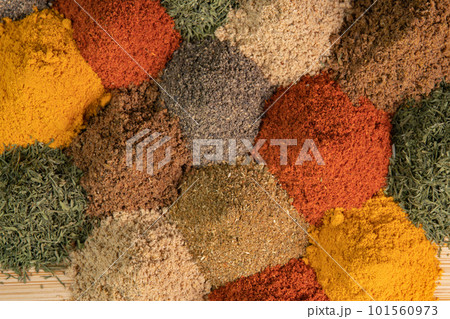Spice and seasoning. Various fragrant spice market. Heap different Asian Spices lies on wooden background. Assortment spices and herbs for cooking 101560973