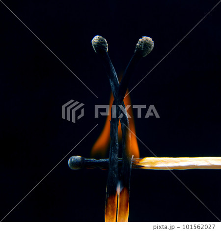 Flashed and burning wooden match on a dark background close-up. Flashed and burning wooden match on a dark background close-up. 101562027
