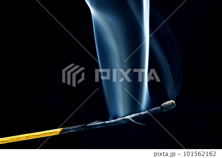 Extinct and fuming wooden match on a dark background close-up. smoke from a burning tree. Extinct and fuming wooden match on a dark background close-up. smoke from a burning tree. 101562162