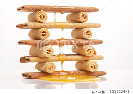 Fresh flower honey flows and drips onto herdry crispy cookie sticks. Dessert snack food. Fresh flower honey flows and drips onto herdry crispy cookie sticks. Dessert snack food. 101562471