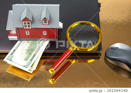 Finding and buying a home over the Internet. House model on the background of a laptop Finding and buying a home over the Internet. House model on the background of a laptop 101564140