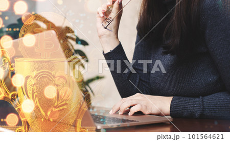 Woman using laptop with bitcoin hologram. Cryptocurrency concept. Double exposure. Woman using laptop with bitcoin hologram. Cryptocurrency concept. Double exposure. 101564621
