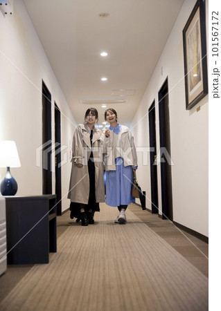 チェックインをしてホテルの廊下を歩く若い女性たち 101567172