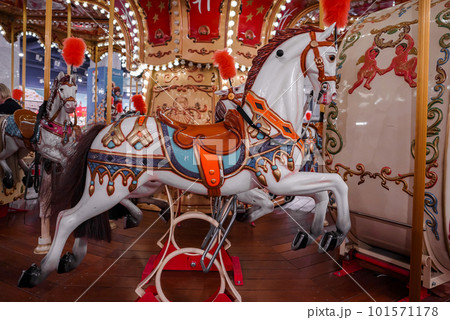 Old French carousel in a holiday park. Three horses and airplane on a traditional fairground vintage carousel. Merry-go-round with horses. 101571178