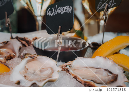 Fresh Oysters close up on a plate, served table with oysters, lemon and ice. Healthy sea food. Fresh Oyster dinner with sparkling wine in a restaurant. Gourmet food Fresh Oysters close up on a plate, served table with oysters, lemon and ice. Healthy sea food. Fresh Oyster dinner with sparkling wine in a restaurant. Gourmet food 101571818