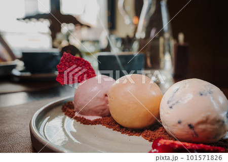 Yummy delicious colorful ice cream on a plate next to the coffee. Yummy delicious colorful ice cream on a plate next to the coffee. 101571826