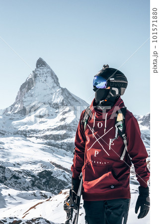 Young snowboarder spending winter holidays in Zermatt, near the famous Matterhorn peak. Male posing in Swiss Alps for the snowboarding season. Young snowboarder spending winter holidays in Zermatt, near the famous Matterhorn peak. Male posing in Swiss Alps for the snowboarding season. 101571880