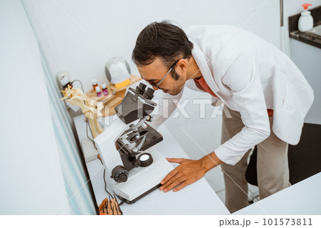 a handsome vet with eye glasses operate the stethoscope 101573811