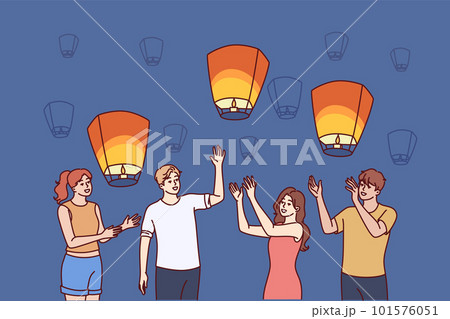 Group of people launch aerial chinese lanterns making cherished wishes during traditional festival 101576051