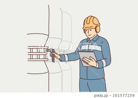 Man working at factory holds electronic tablet standing near industrial equipment and tanks 101577259
