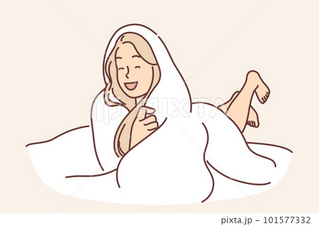 Laughing woman wrapped in blanket lies on bed not wanting to get up and go to work or college 101577332