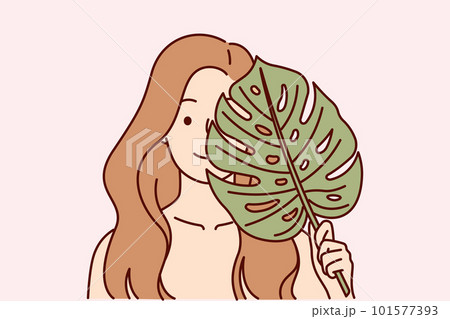 Beautiful woman applies leaf from palm tree to face, symbolizing natural cosmetic product for skin Beautiful woman applies leaf from palm tree to face, symbolizing natural cosmetic product for skin 101577393