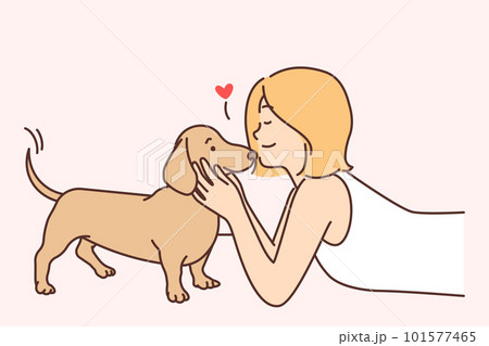 Cute girl kissing puppy enjoying communication with beloved pet and caring for dachshund 101577465