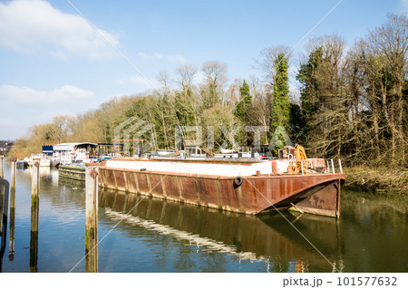 ロンドン郊外を流れるテームズ川に停泊する細長いボート 101577632