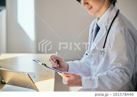 オンライン診療をする白衣の若い男性 オンライン診療をする白衣の若い男性 101578440