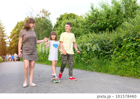 Happy family walking around public park during sunny day 101578460