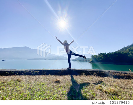 湖に向かって万歳する女性の後ろ姿 101579416