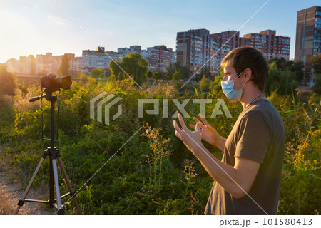 A man wearing a medical mask records a video blog on how to protect himself from the virus A man wearing a medical mask records a video blog on how to protect himself from the virus 101580413