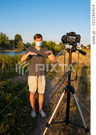 A blogger wearing a medical mask is recording a video blog on how to protect himself from the virus A blogger wearing a medical mask is recording a video blog on how to protect himself from the virus 101580424