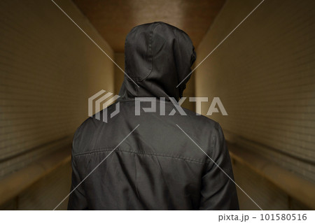 A man in a hood on the street. Social problems, drug addiction and criminal activity. A man in a hood on the street. Social problems, drug addiction and criminal activity. 101580516