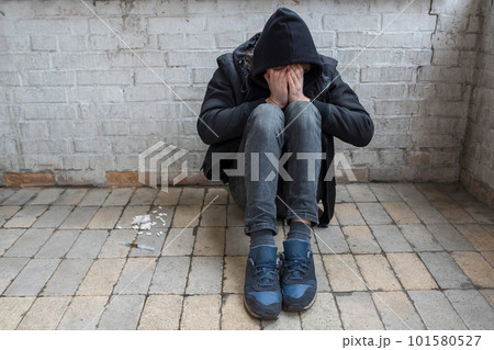 Addict and drugs in an abandoned house. International Drug Abuse Day. Addiction concept 101580527