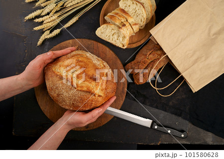 The healthy eating and traditional bakery concept. Top viev. Fresh bread on table close-up. Fresh bread on the kitchen table Whole grain bread put on kitchen wood plate with a chef near knife ready The healthy eating and traditional bakery concept. Top viev. Fresh bread on table close-up. Fresh bread on the kitchen table Whole grain bread put on kitchen wood plate with a chef near knife ready 101580628