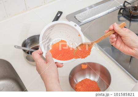 【イクラの醤油漬けを作るために、お酒が馴染んだ生イクラをボウルに移す】 101585821