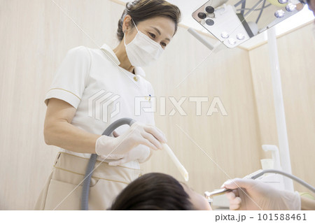歯の治療を受ける子供とミドル歯科衛生士 歯の治療を受ける子供とミドル歯科衛生士 101588461