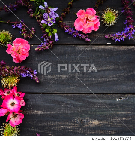 Flowers in a semicircle on a wooden background. Postcard for the holiday. Roses, lavender, sage and hairy chestnuts along the edges on dark boards. Background copy space, flat lay. Festive poster. Flowers in a semicircle on a wooden background. Postcard for the holiday. Roses, lavender, sage and hairy chestnuts along the edges on dark boards. Background copy space, flat lay. Festive poster. 101588874