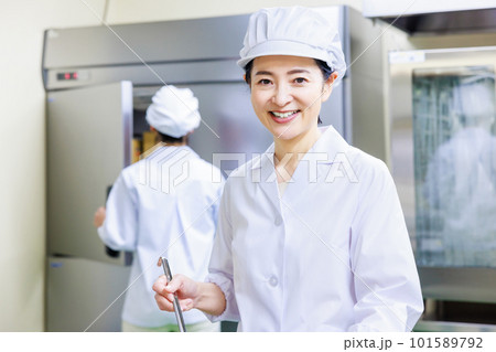 厨房で料理を作る白衣を着た女性調理師 101589792