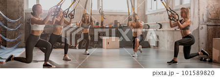Group of young fitness people using fitness straps in sports club 101589820