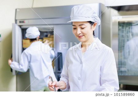 厨房で料理を作る白衣を着た女性調理師 厨房で料理を作る白衣を着た女性調理師 101589860