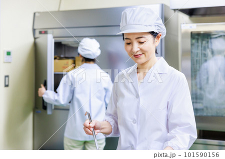 厨房で料理を作る白衣を着た女性調理師 厨房で料理を作る白衣を着た女性調理師 101590156