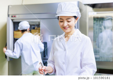 厨房で料理を作る白衣を着た女性調理師 厨房で料理を作る白衣を着た女性調理師 101590181