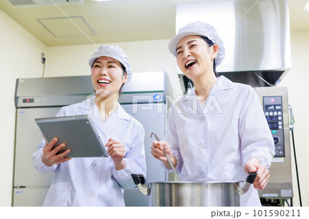 厨房で料理を作る白衣を着た女性調理師 101590211