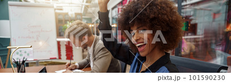 Happy african businesswoman sitting on his workplace in modern office on colleague background 101590230