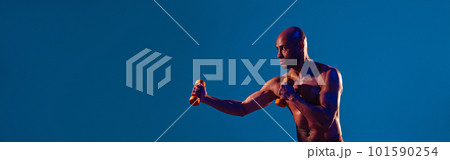 Muscular man doing exercise with weight dumbbells on studio background. Strength and motivation Muscular man doing exercise with weight dumbbells on studio background. Strength and motivation 101590254